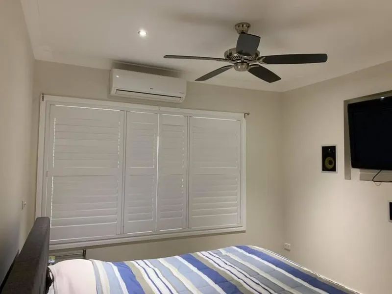 Bedroom With a Bed, Window Shutters, Ceiling Fan — Paint Place Cowra in Cowra, NSW
