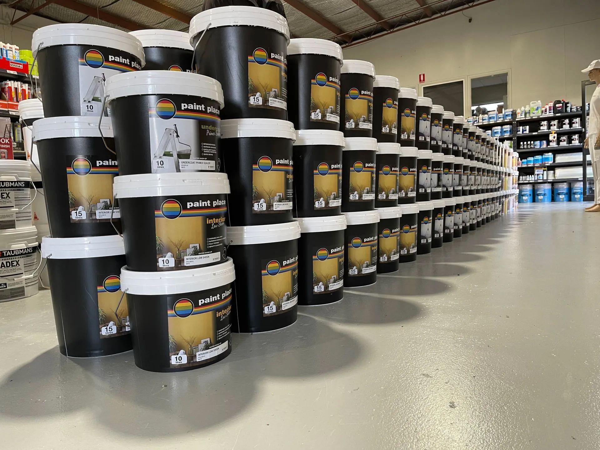 Aisle With Stacked Black Paint Buckets in a Hardware Store — Paint Place Cowra in Forbes, NSW