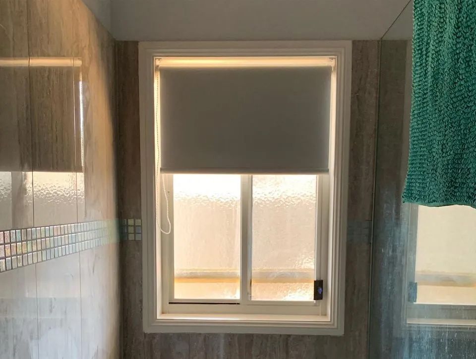 Bathroom Window With White Roller Blind — Paint Place Cowra in Cowra, NSW