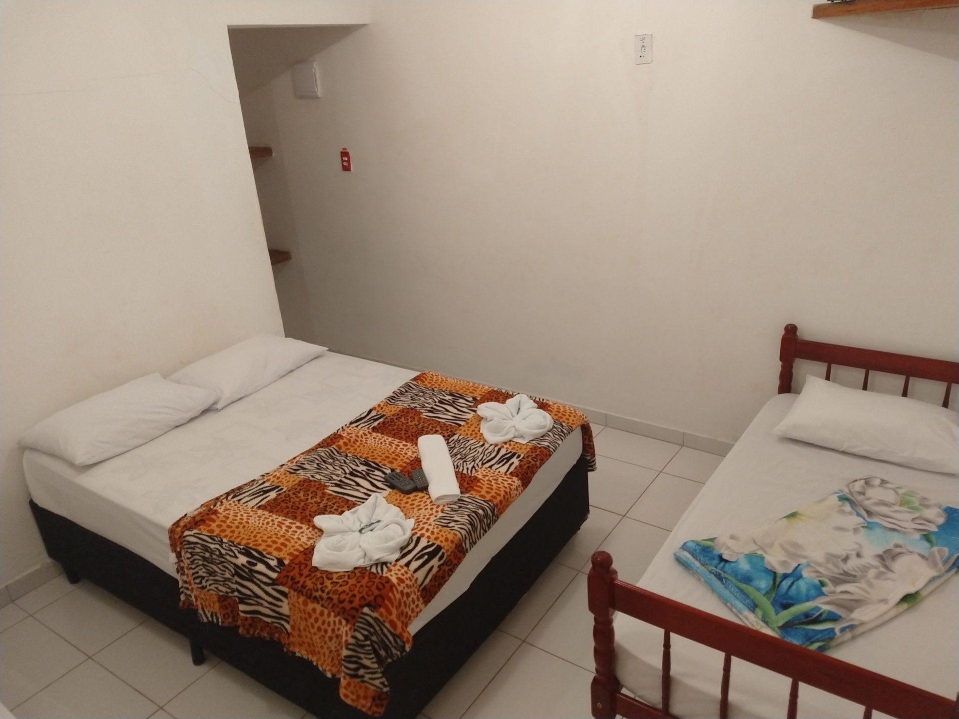Um quarto de hotel com uma cama e duas camas