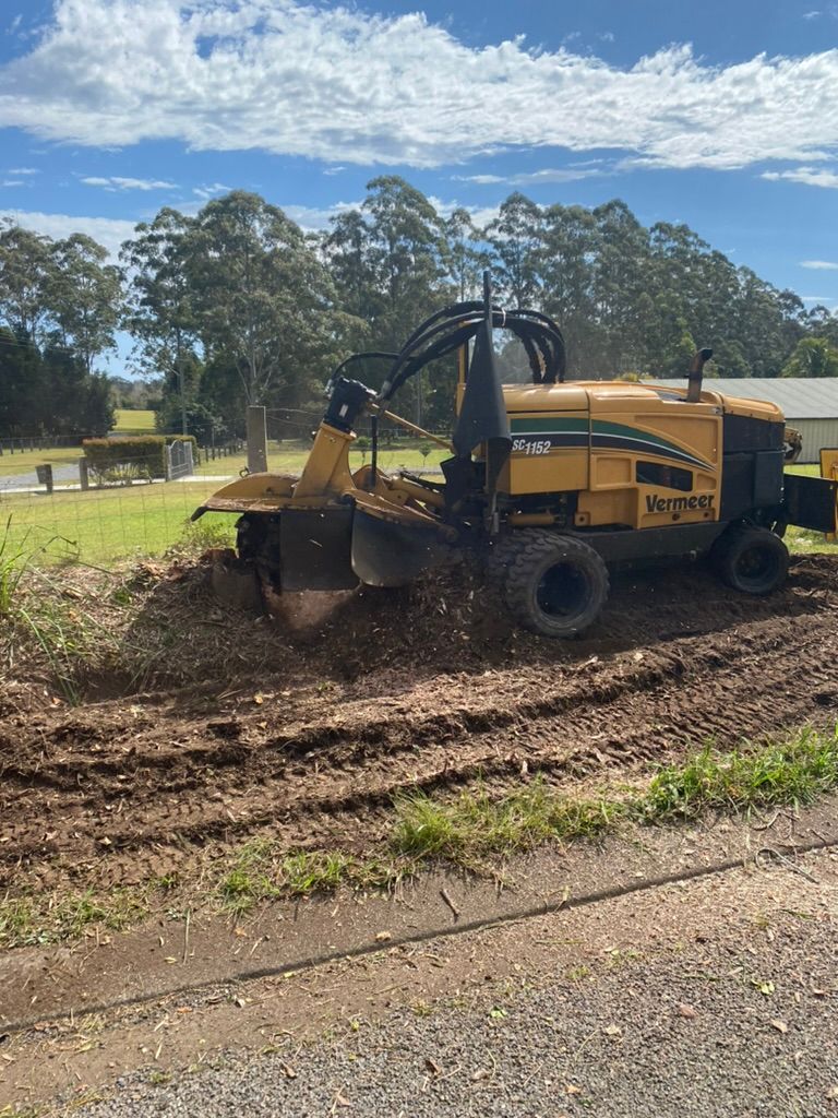 A Yellow Tractor Is Cutting a Tree Stump — MNC Trees in Port Macquarie, NSW