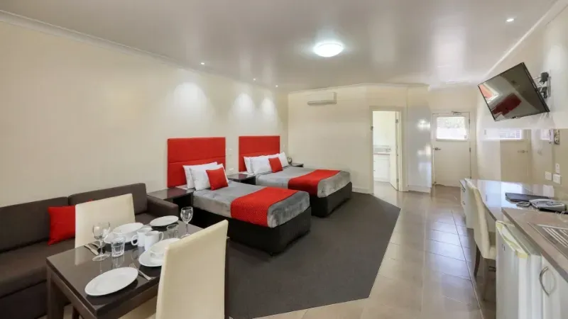 Swagsman Motor Inn suite with two beds, a sofa and a dining table