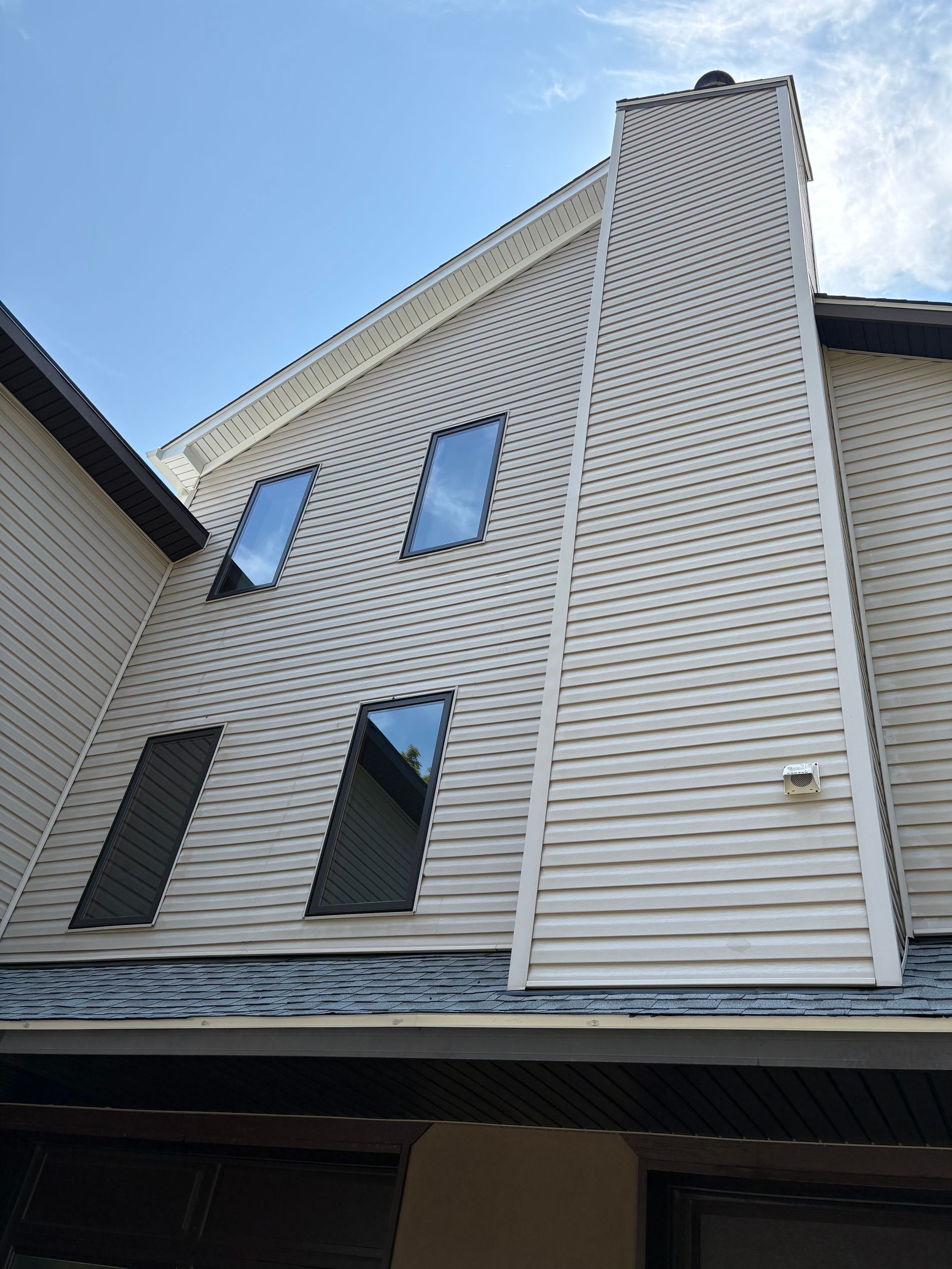 A man is using a yellow machine to clean a sidewalk.