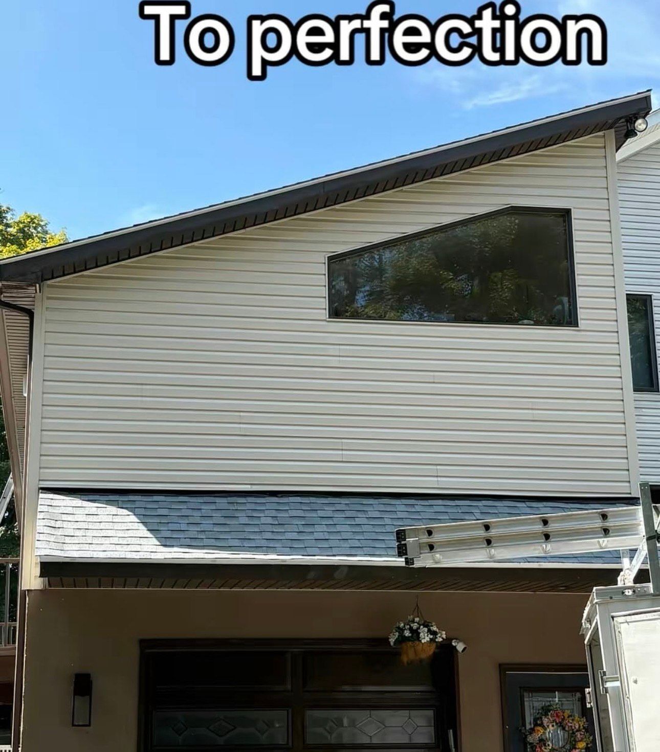 A man is using a high pressure washer to clean a siding