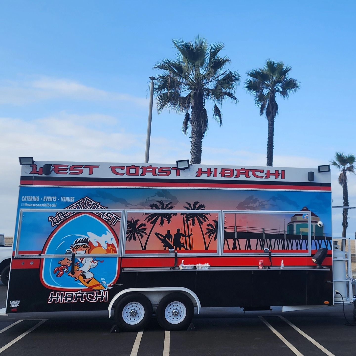 A west coast hibachi food truck is parked in a parking lot