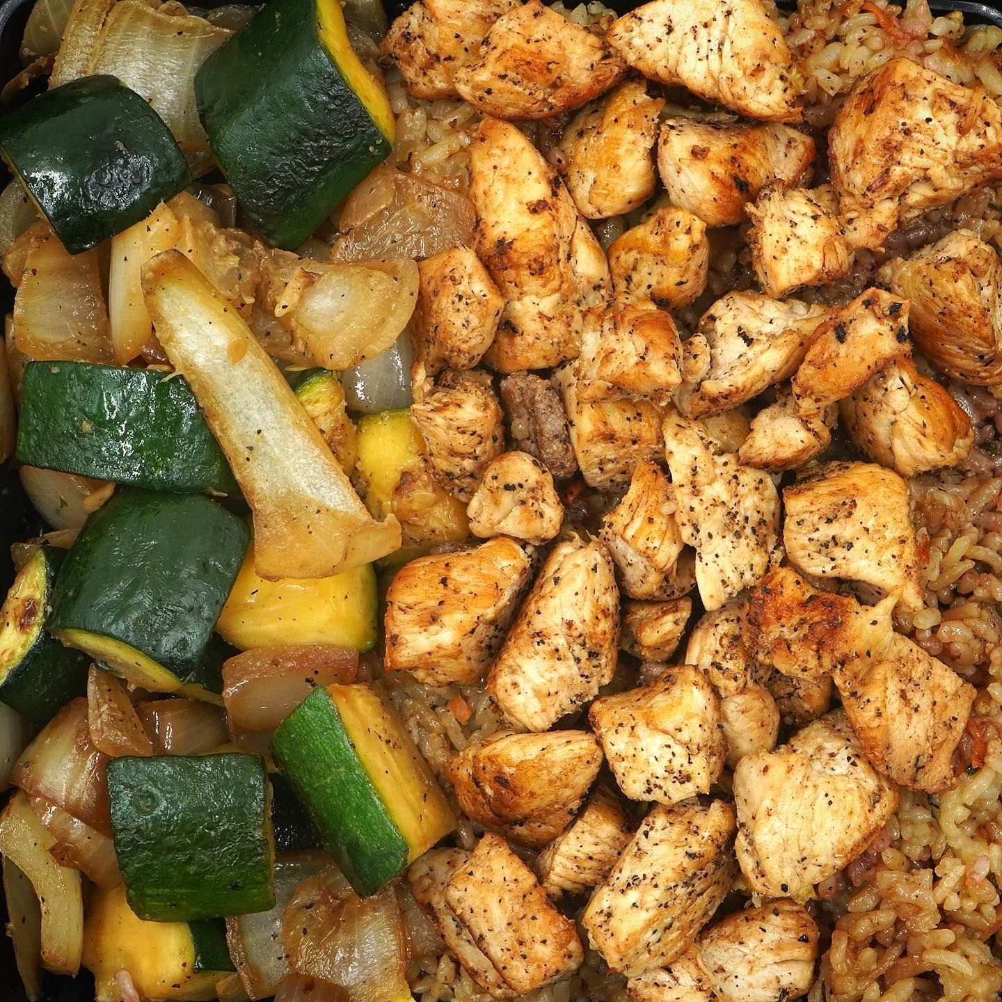 A close up of a plate of food with chicken and rice