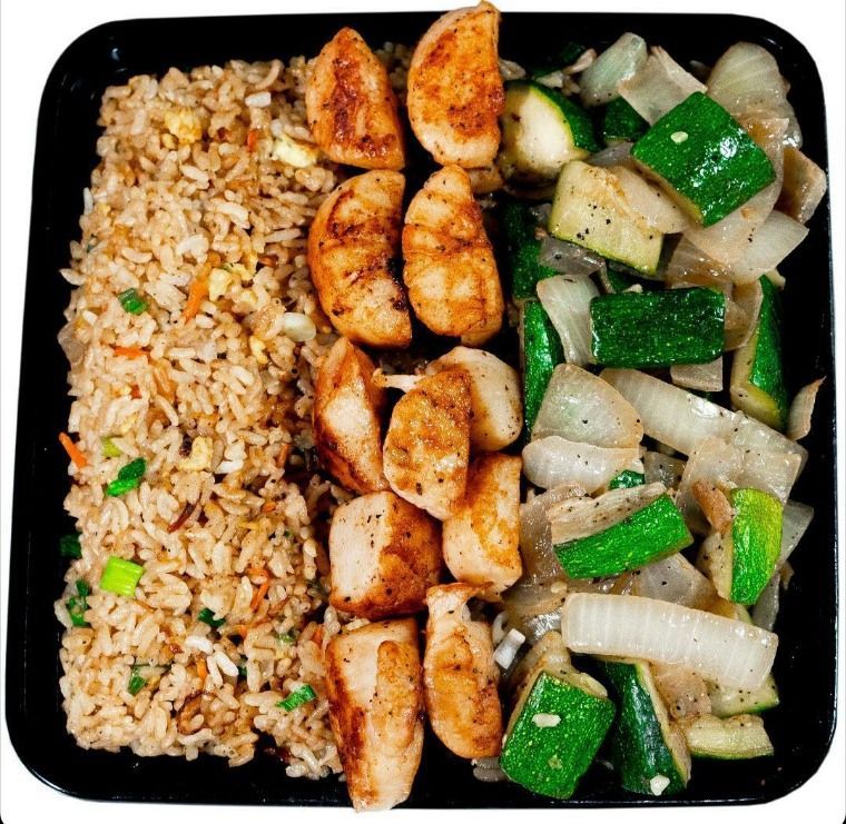 A plate of food with rice chicken and vegetables on a white background
