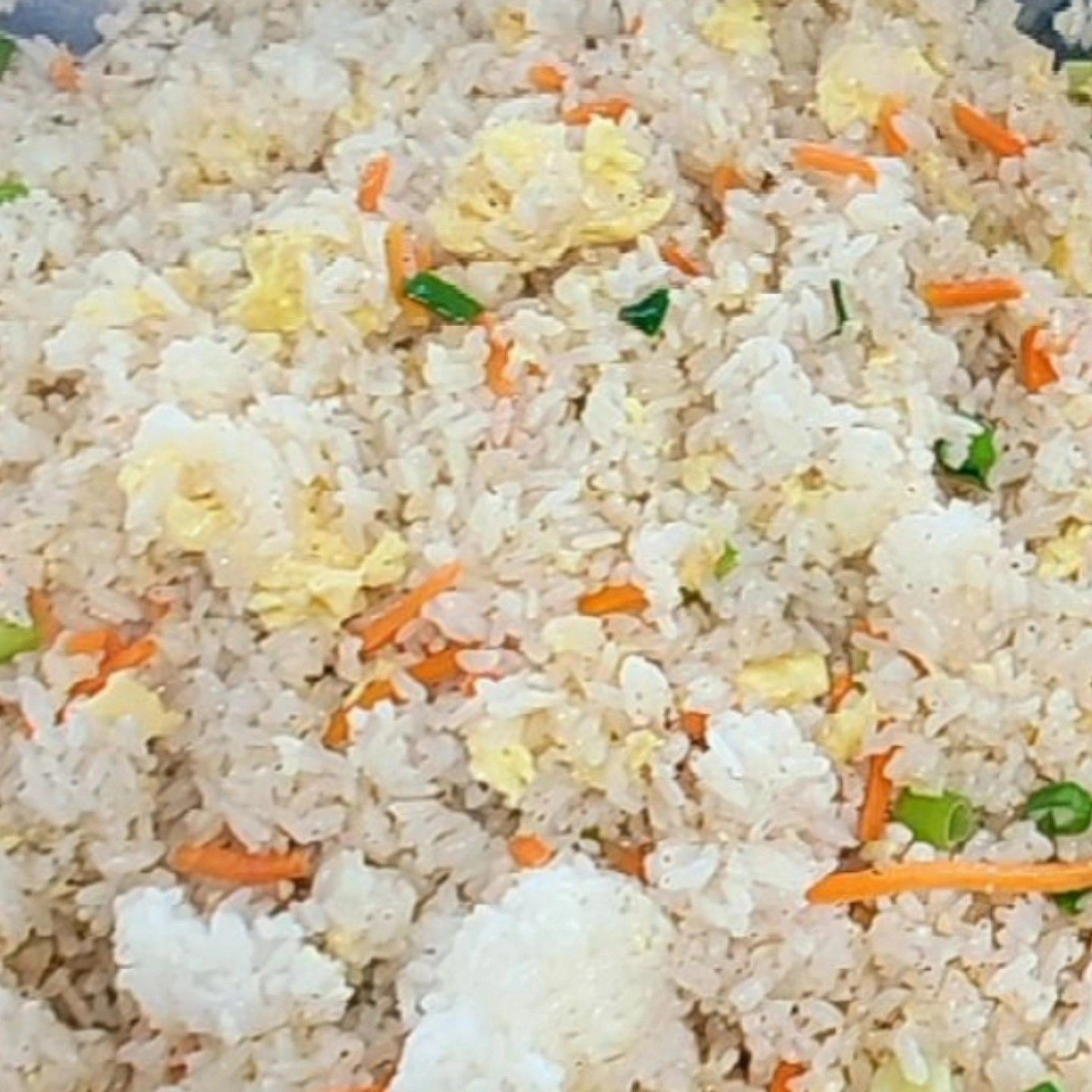 A close up of a pile of rice with carrots and eggs.