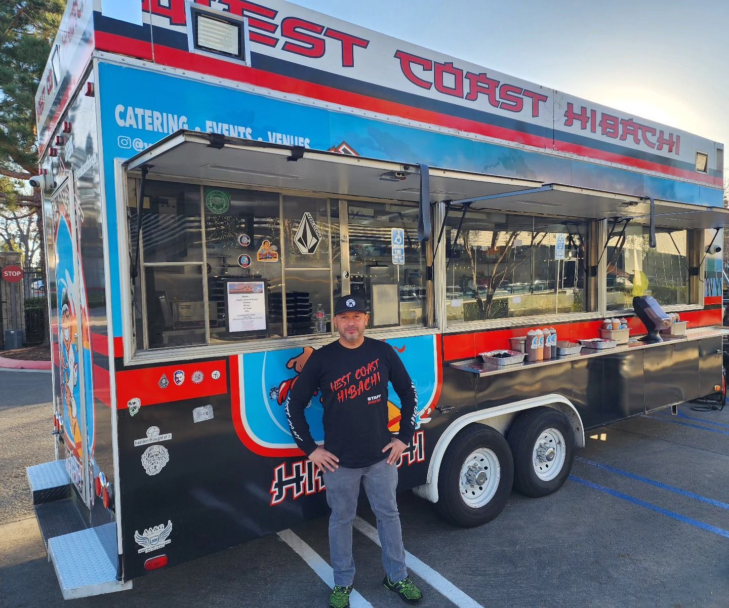 A man is standing in front of a food truck.