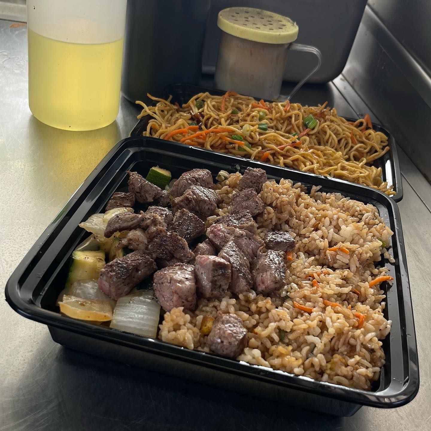 A tray of food with rice and meat on a table