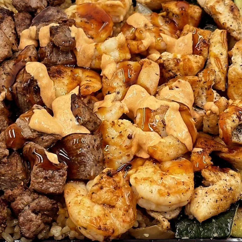 A close up of a plate of food with meat and shrimp.