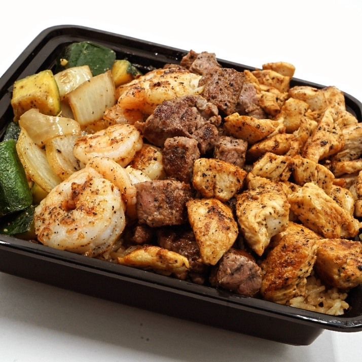A black plastic container filled with meat and shrimp