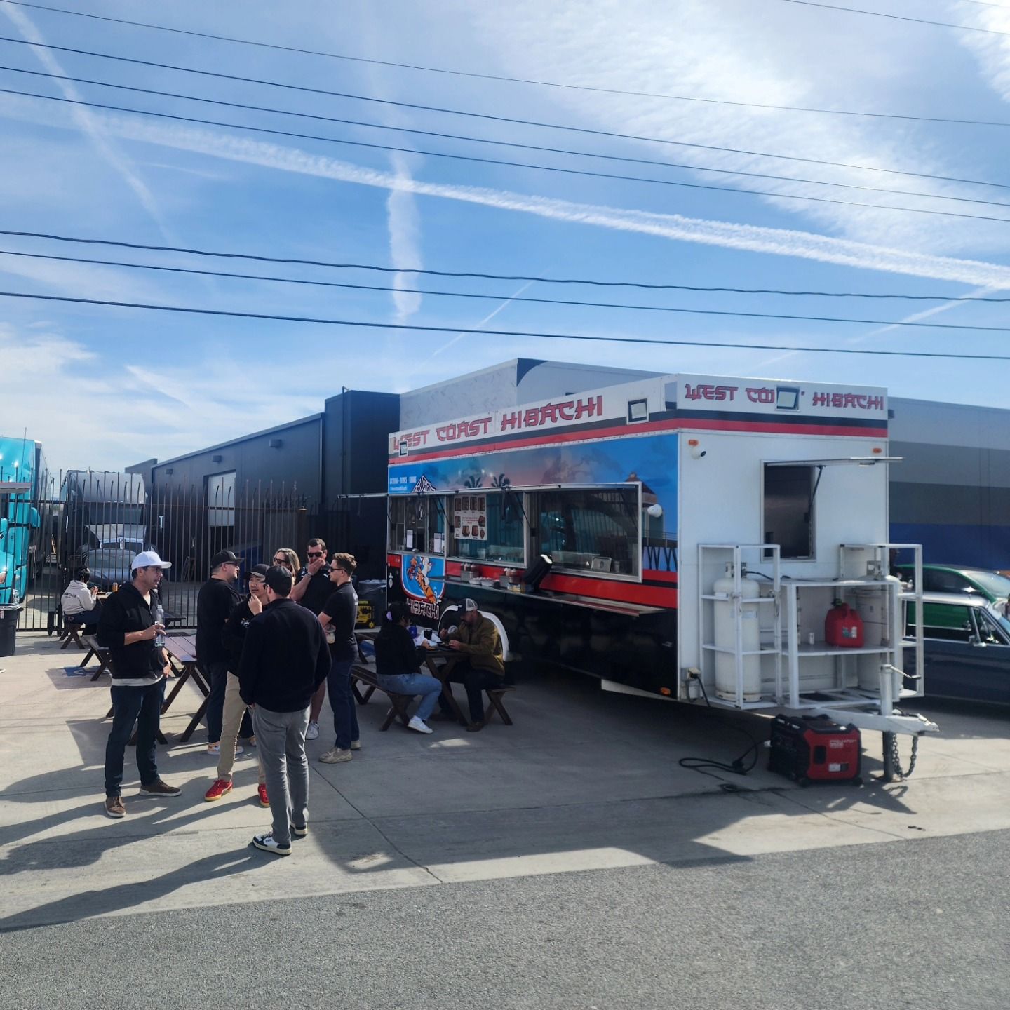 A group of people are gathered outside of a food truck that says last stop in burchi