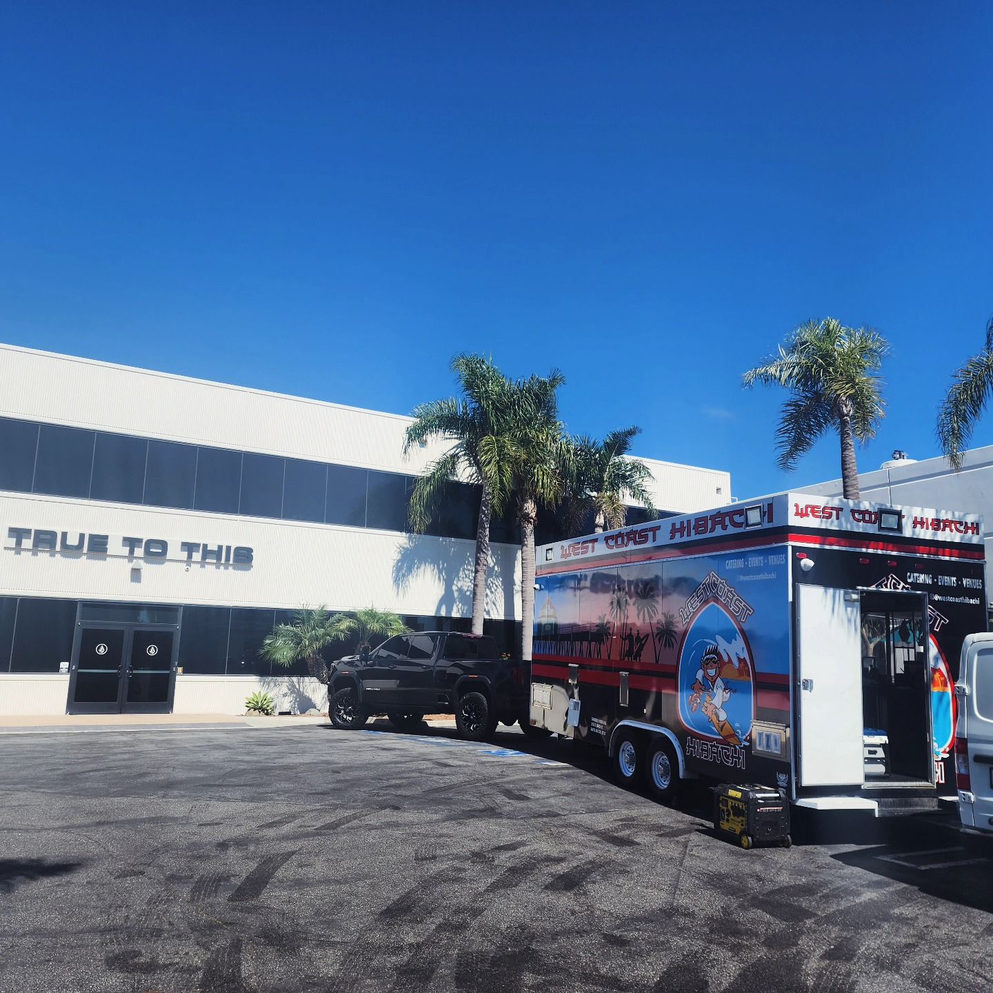A truck is parked in front of a building that says true to this