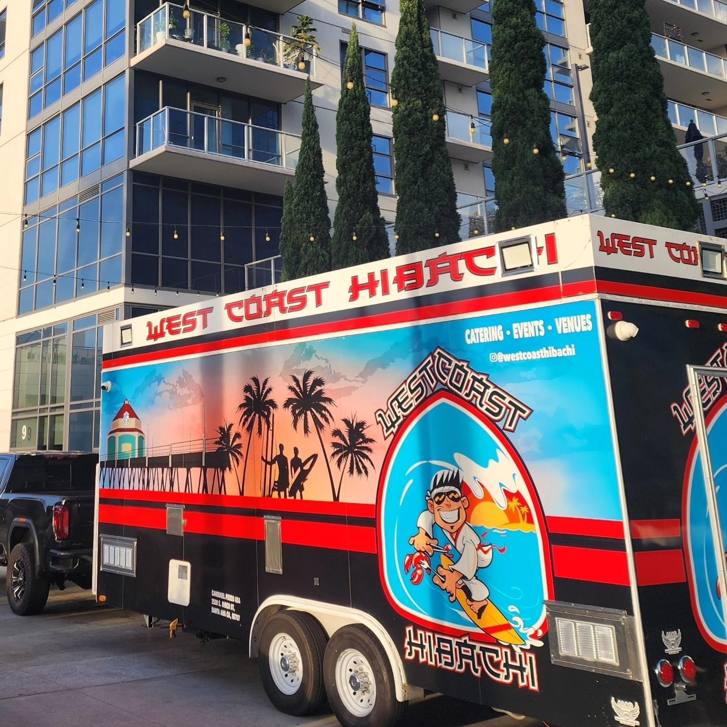 A west coast hi-fi truck is parked in front of a building