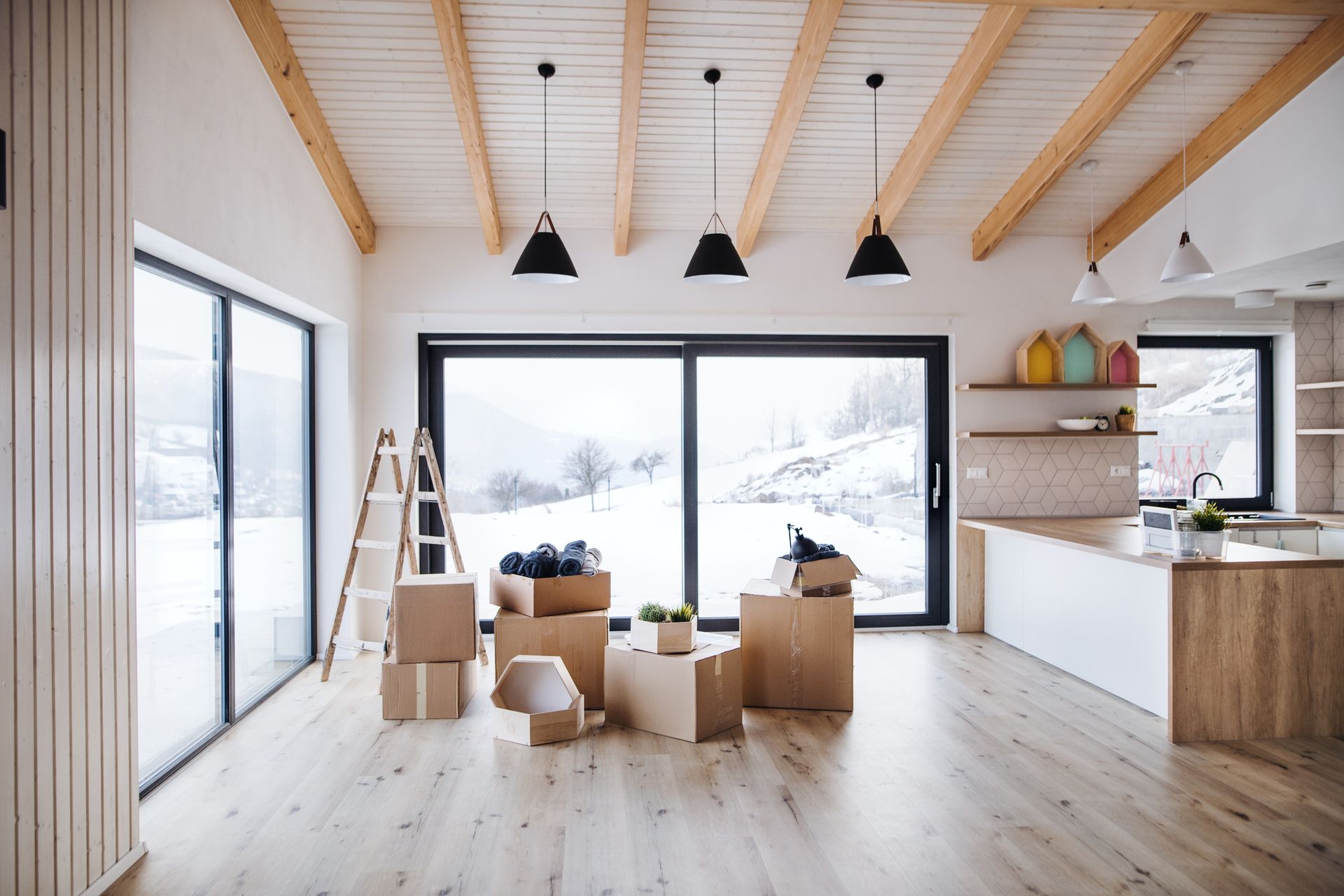 A living room with boxes and a ladder in it.