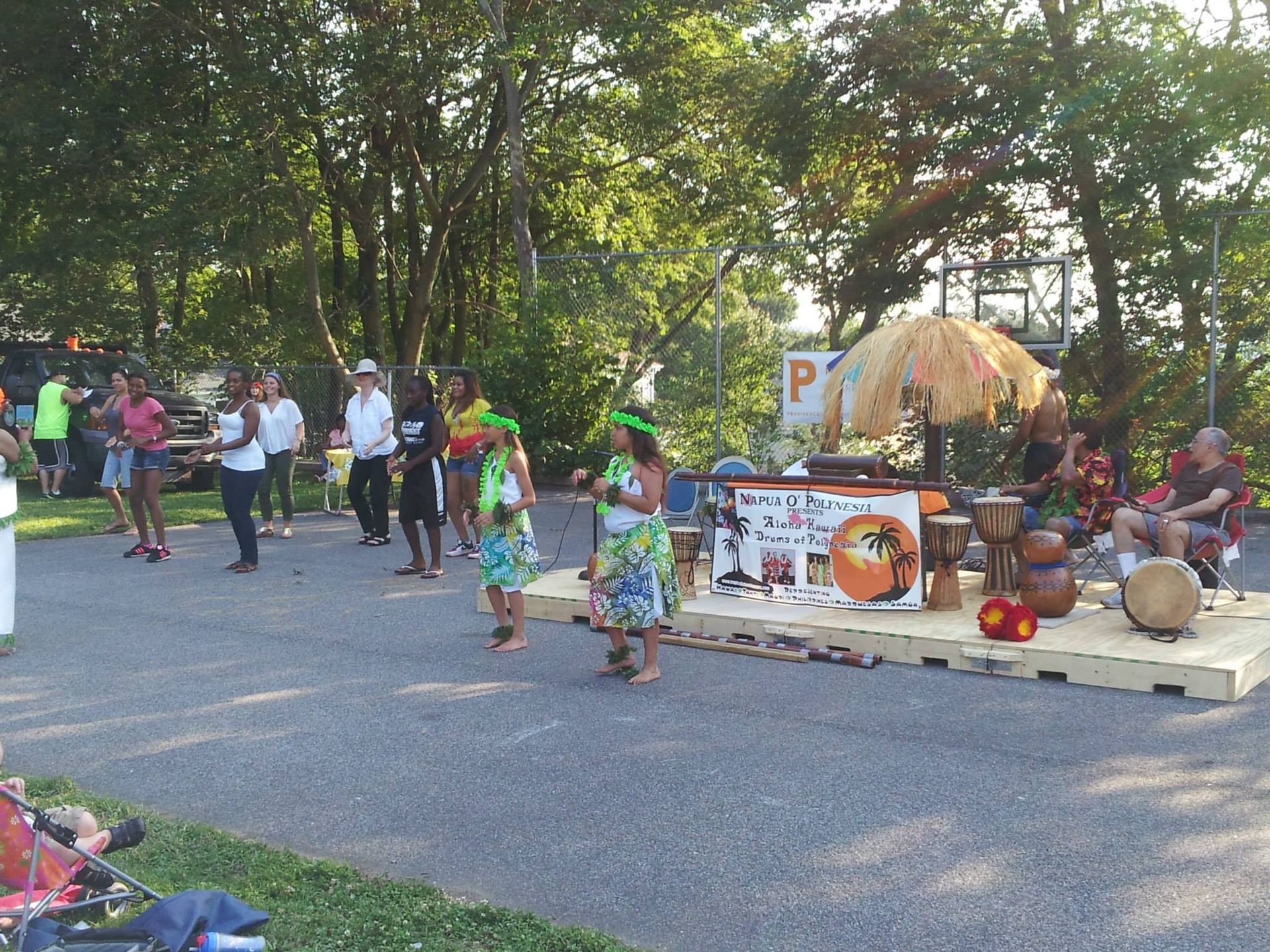 A group of people are dancing in front of a sign that says p.
