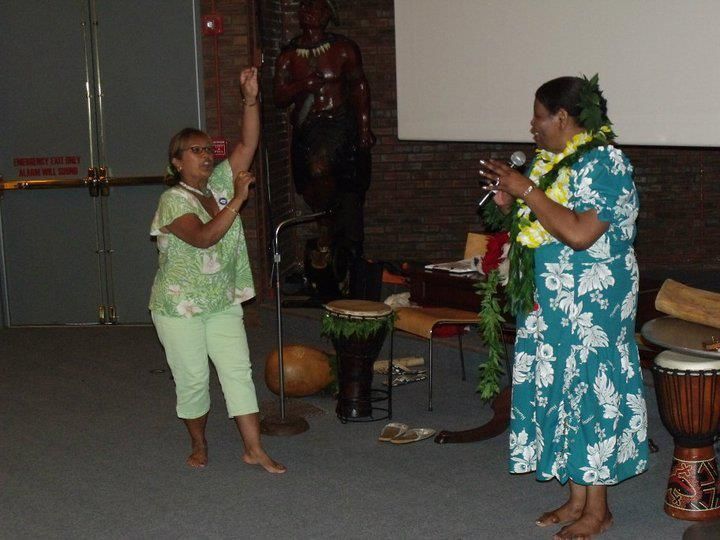 A woman singing into a microphone next to another woman
