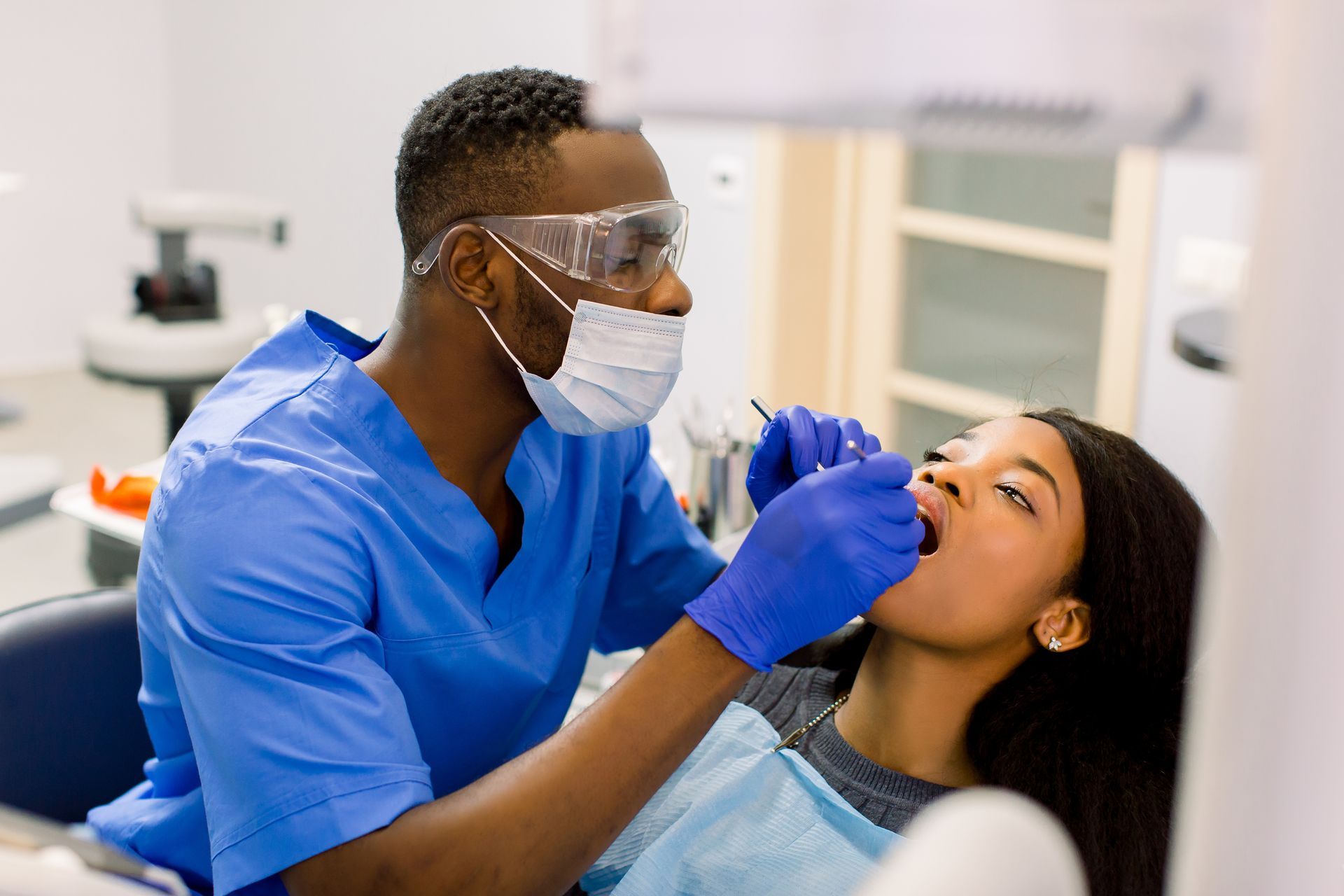 A dentist is doing a dental cleaning for a patient.