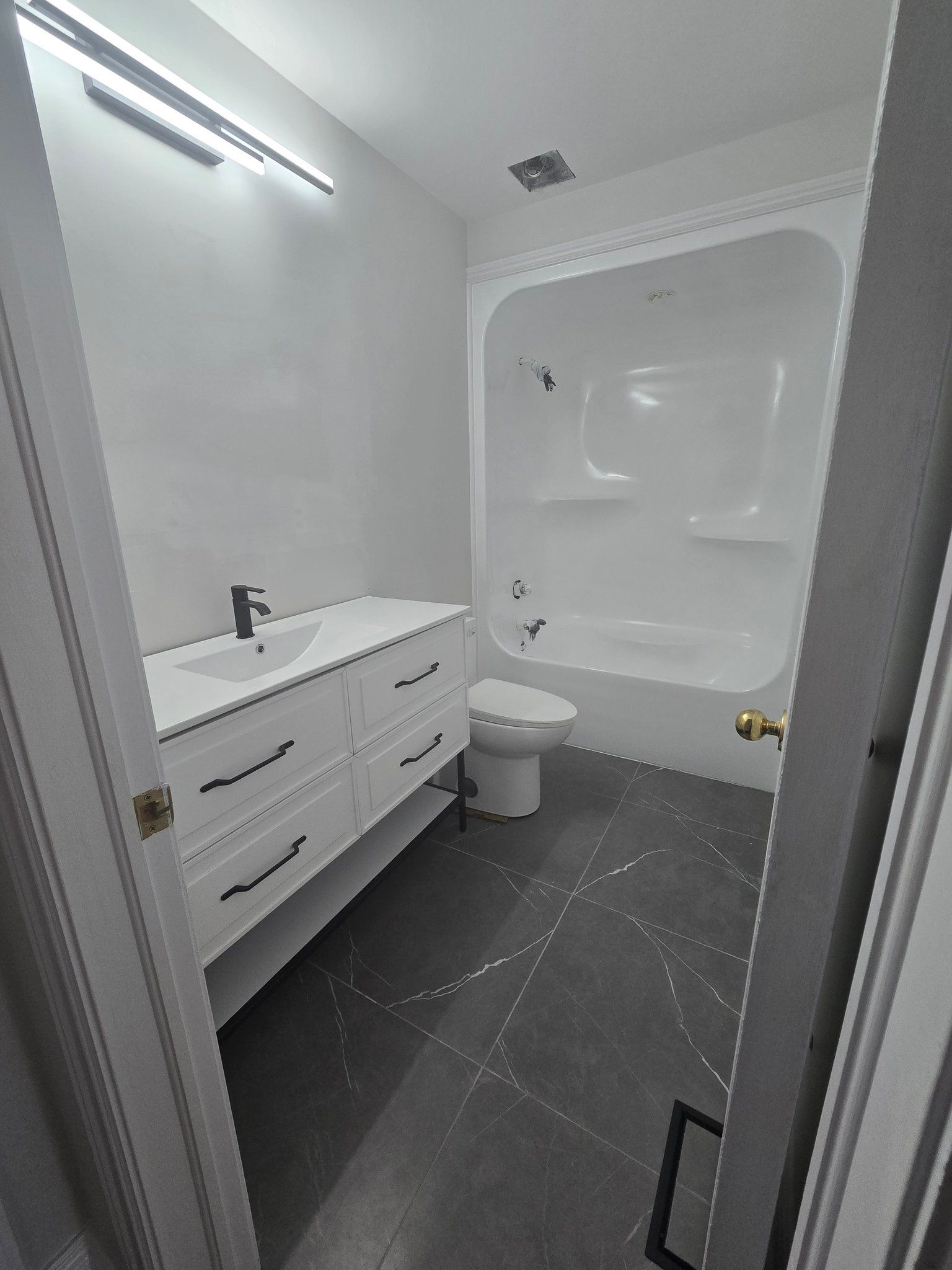 A bathroom with a toilet , sink , bathtub and shower.