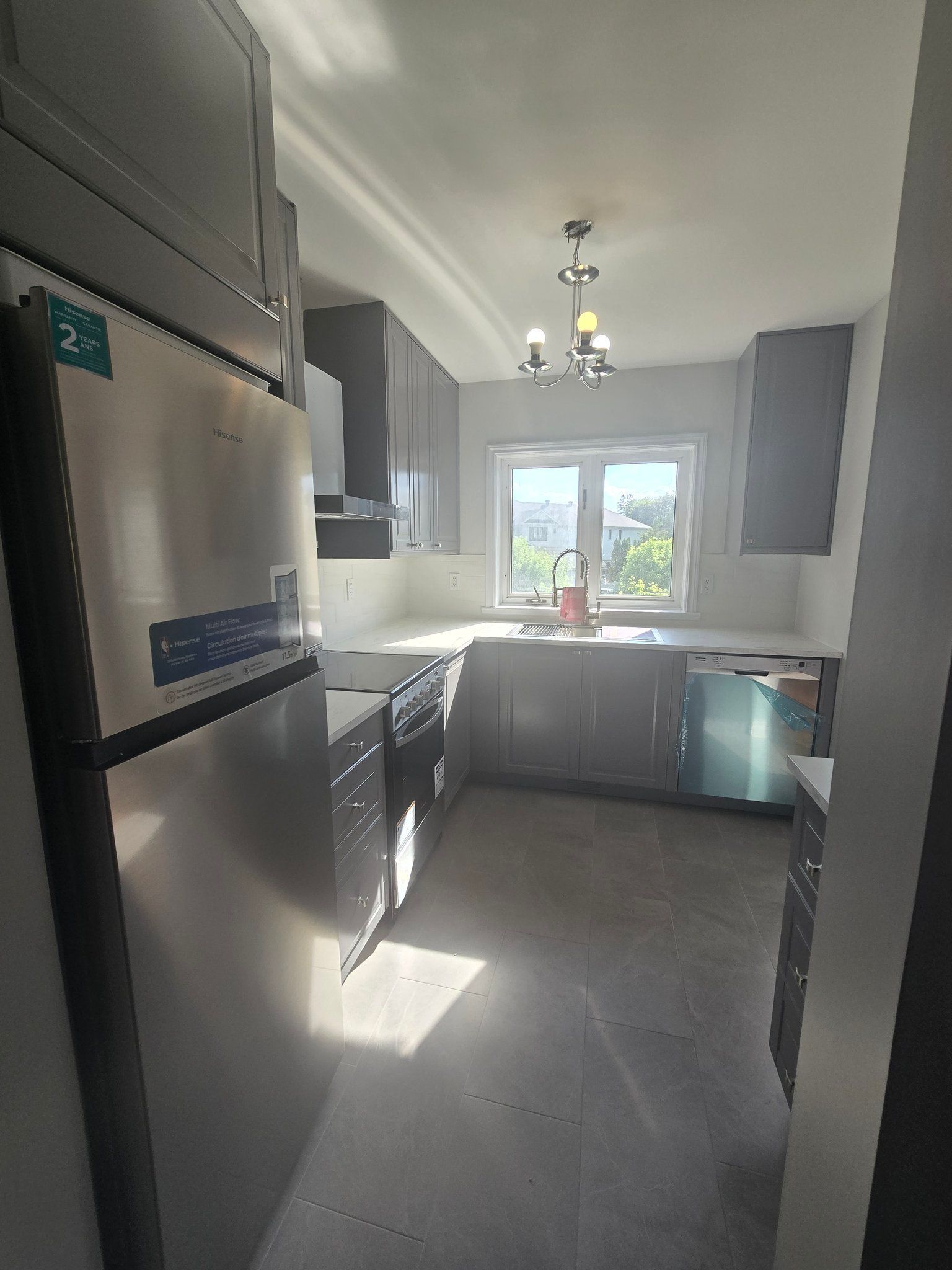 A kitchen with stainless steel appliances and gray cabinets