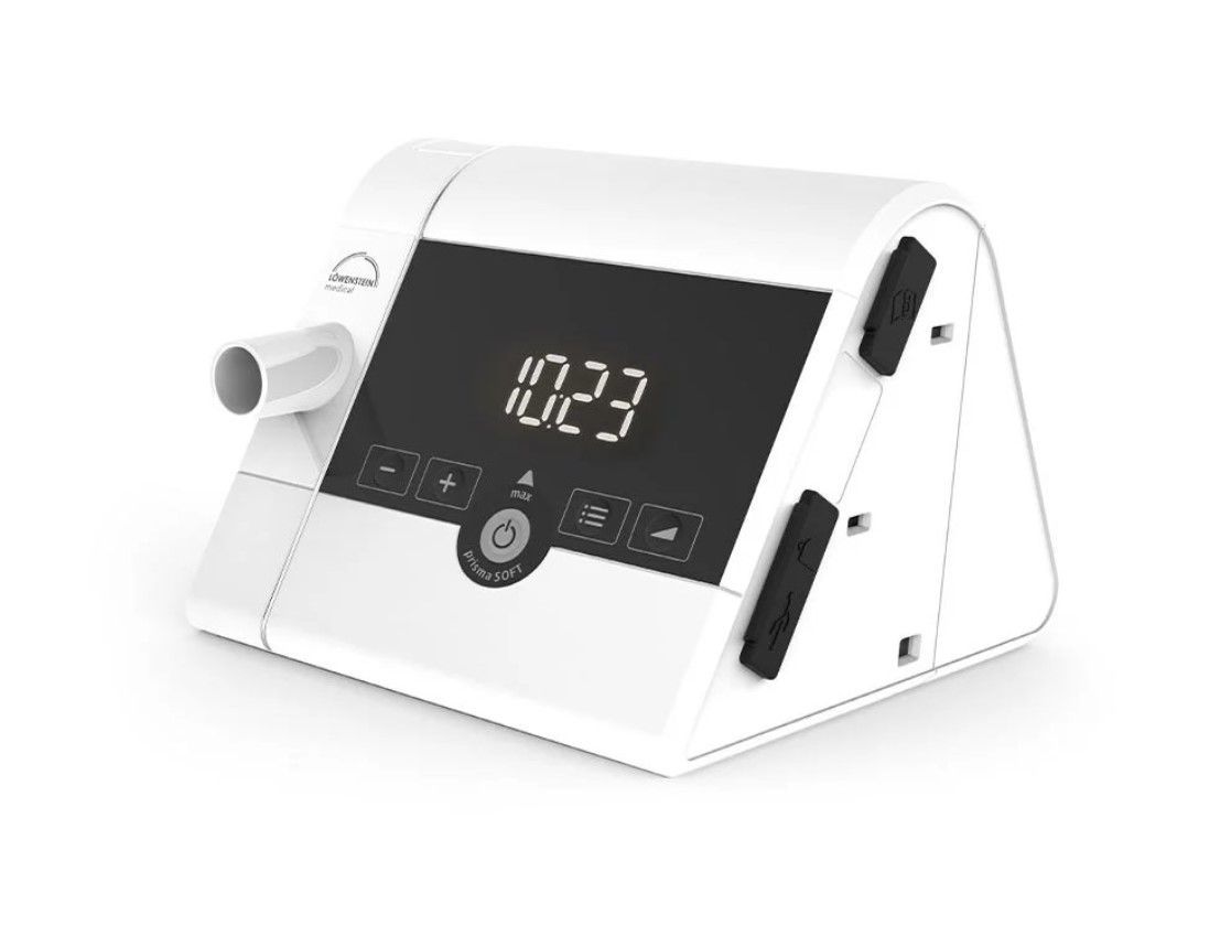Vit CPAP-maskin med digital display som visar tiden.