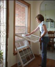 Woman Cleaning the Window — Dover, OH — Wallick's Seamless Spouting LLC Woman Cleaning the Window — Dover, OH — Wallick's Seamless Spouting LLC