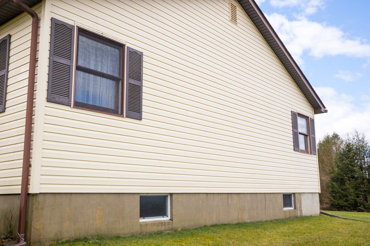 House with Pale Yellow Vinyl Siding — Dover, OH — Wallick's Seamless Spouting LLC