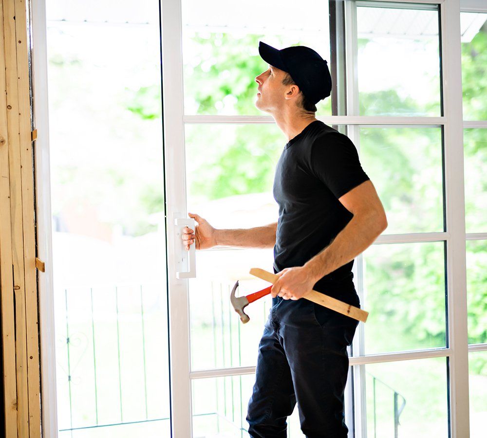 Young Man Installing Double Sliding Patio Door — Dover, OH — Wallick's Seamless Spouting LLC Young Man Installing Double Sliding Patio Door — Dover, OH — Wallick's Seamless Spouting LLC