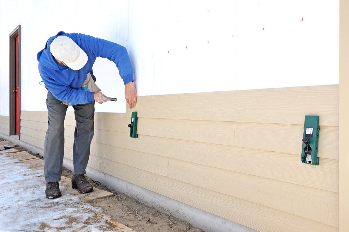Man Installing Siding — Dover, OH — Wallick's Seamless Spouting LLC