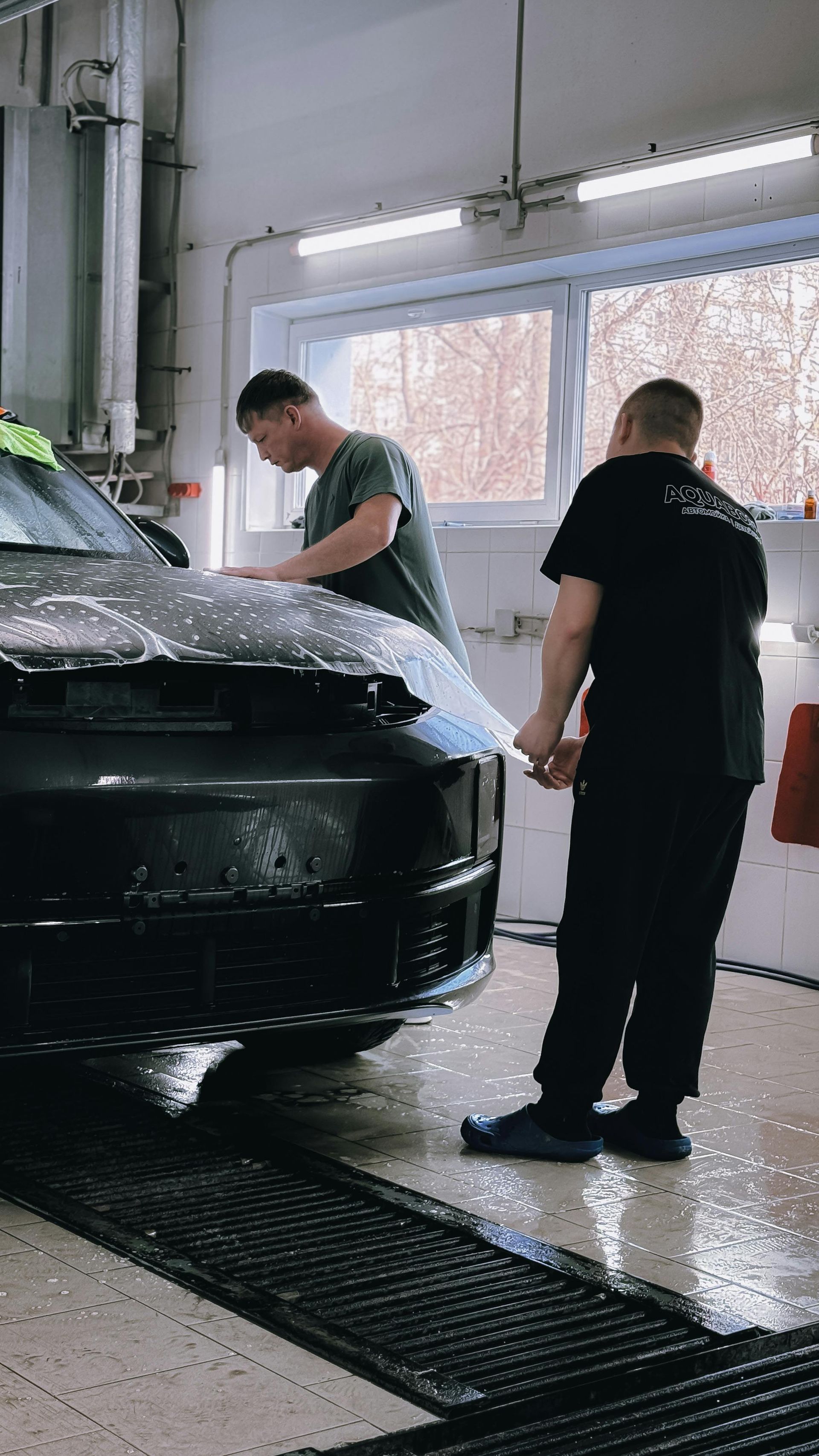 A white ford mustang is being washed in a car wash.
