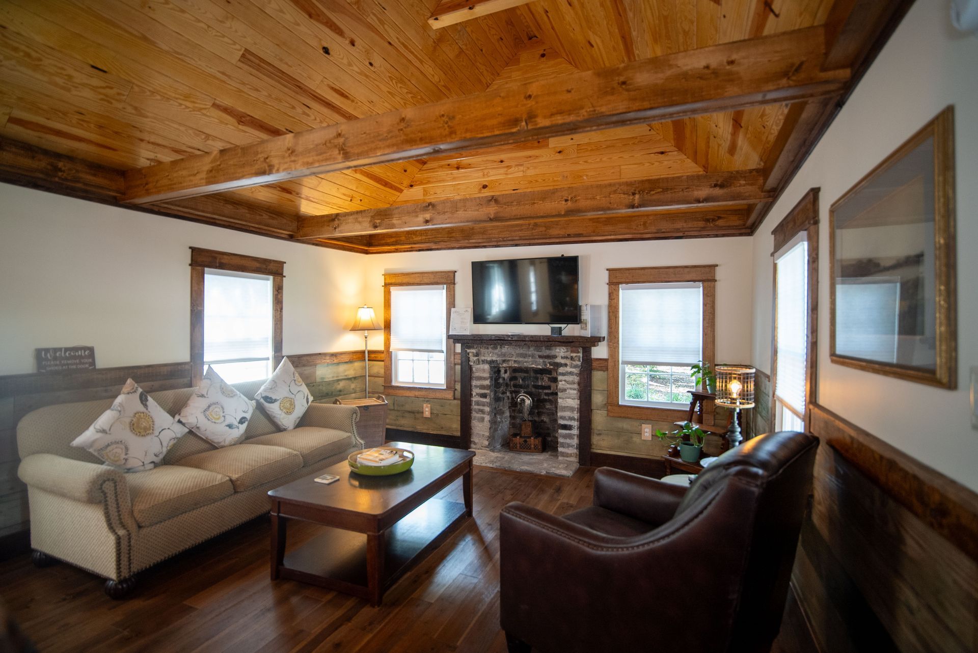 a living room with a couch , chairs , coffee table and fireplace .