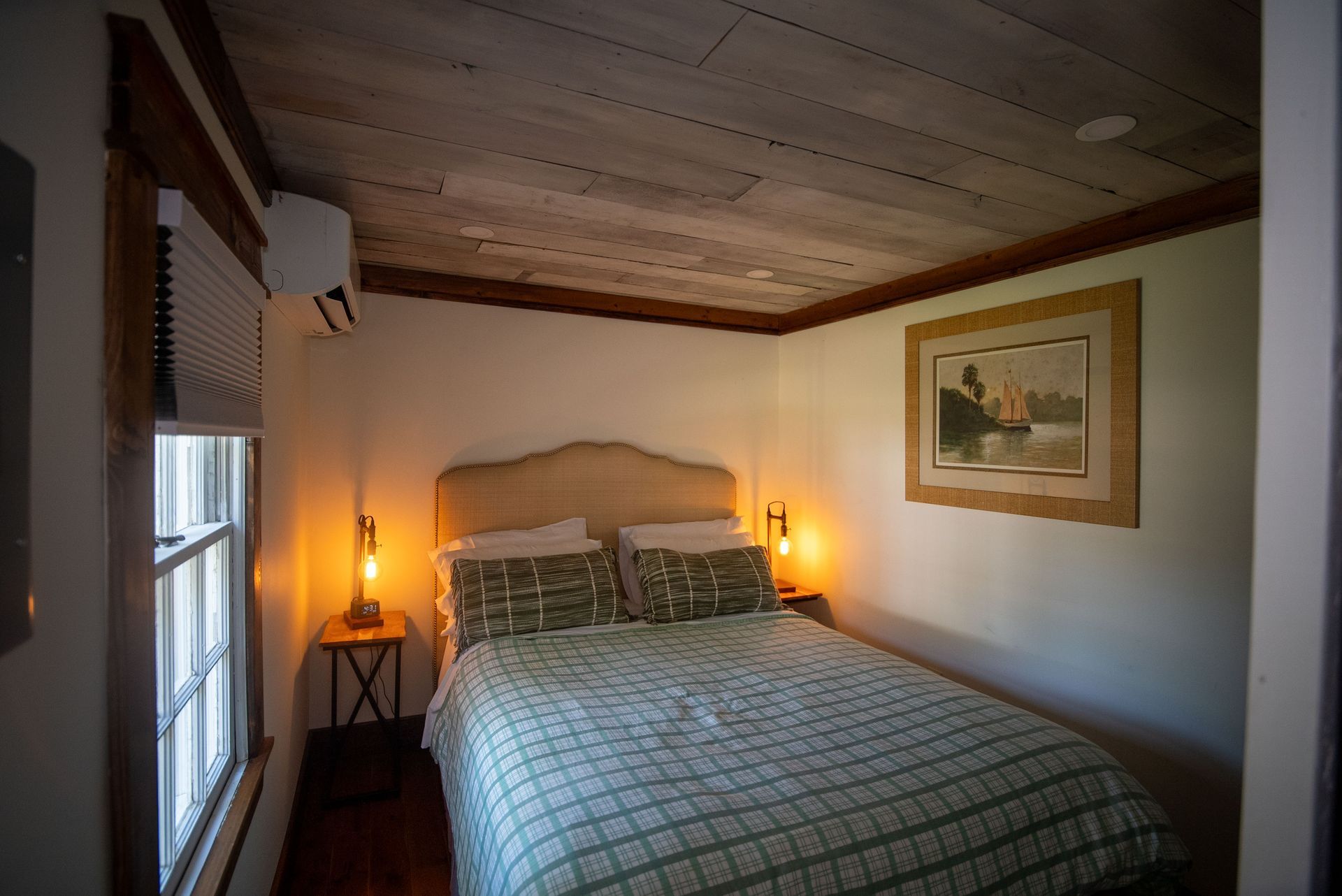a bedroom with a bed and a picture on the wall .