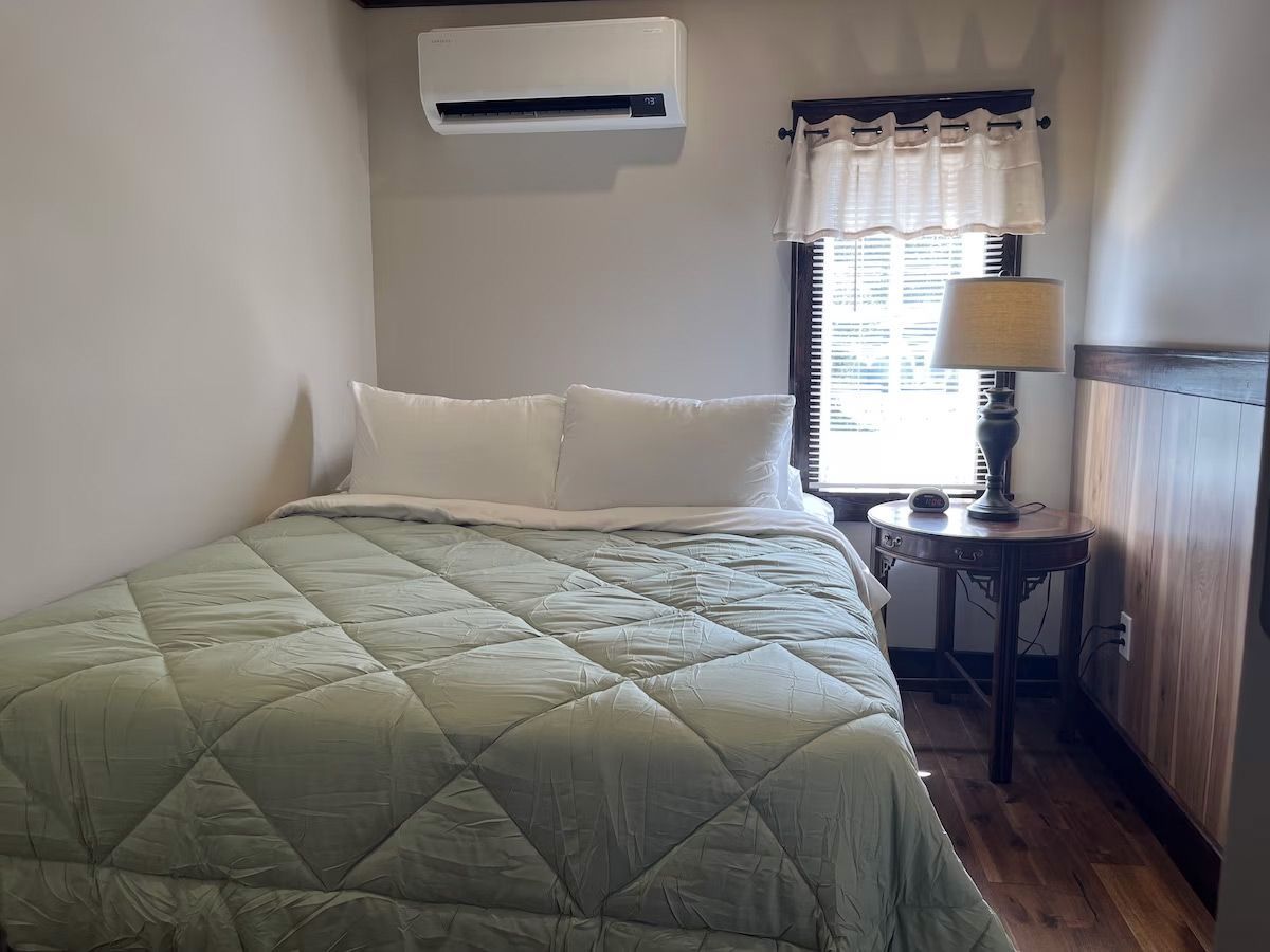 a small bedroom with a bed and a window