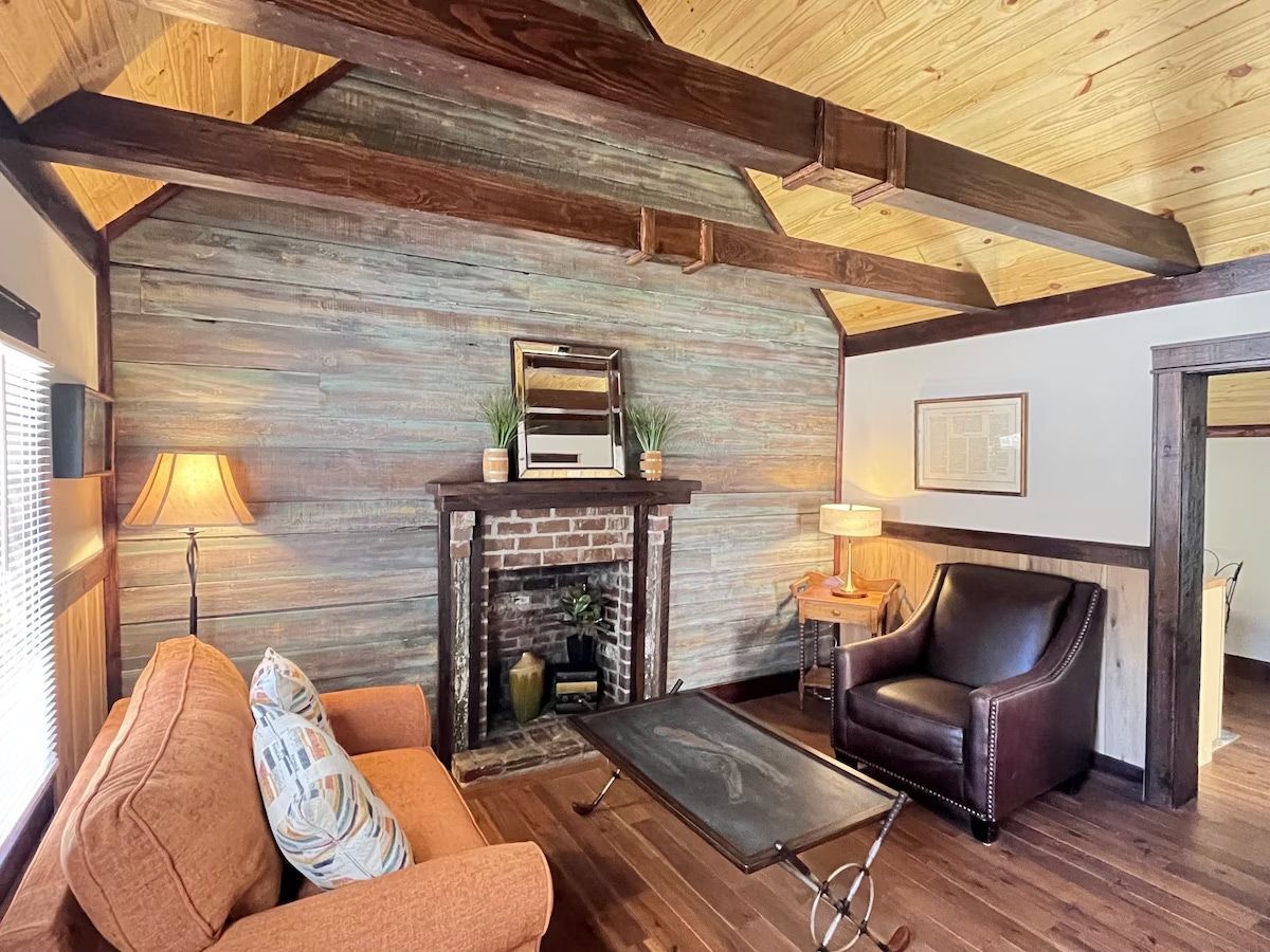 a living room with a couch , chair , coffee table and fireplace .