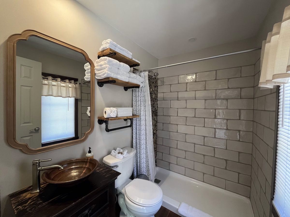 a bathroom with a sink , toilet , shower and mirror .