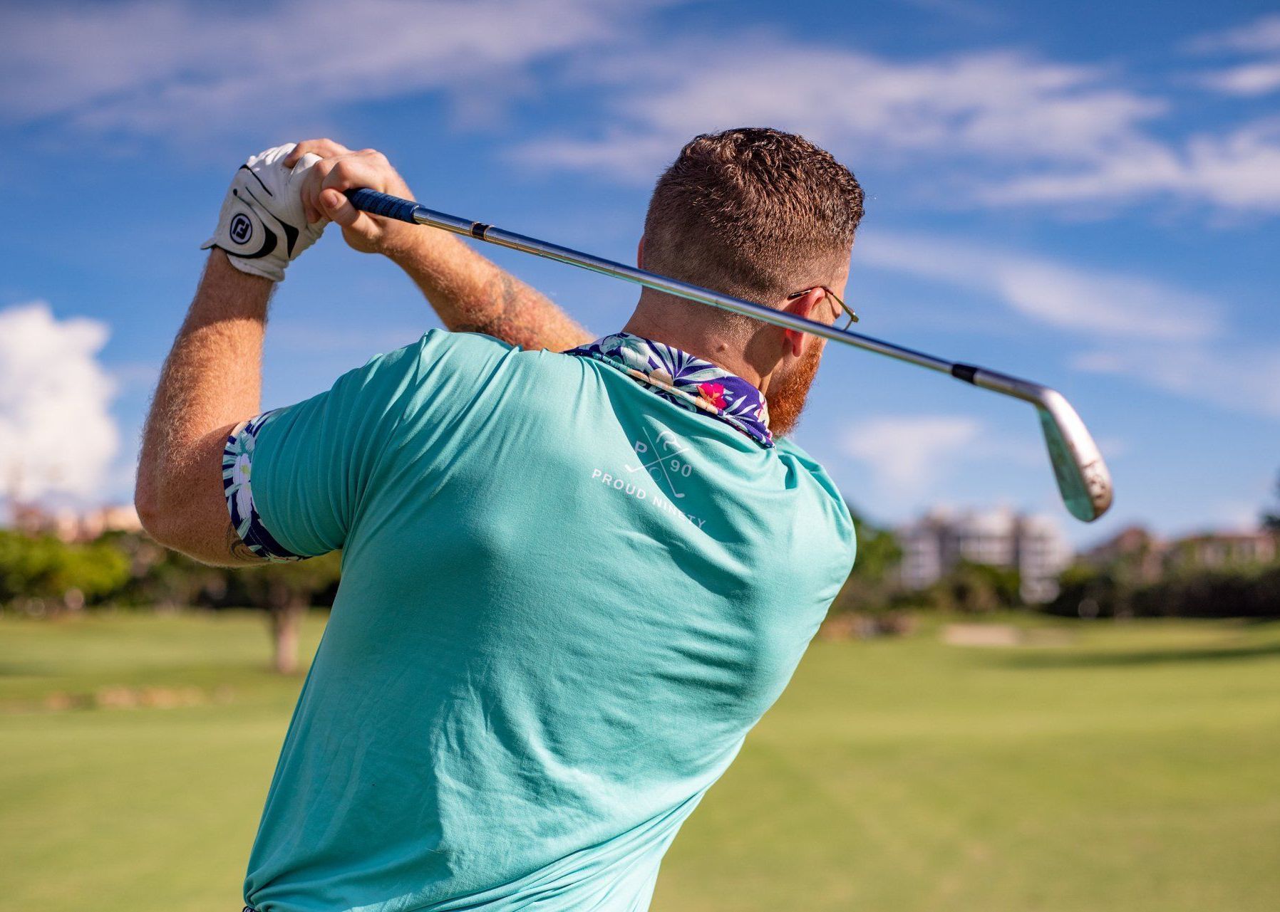 a man is swinging a golf club on a golf course .