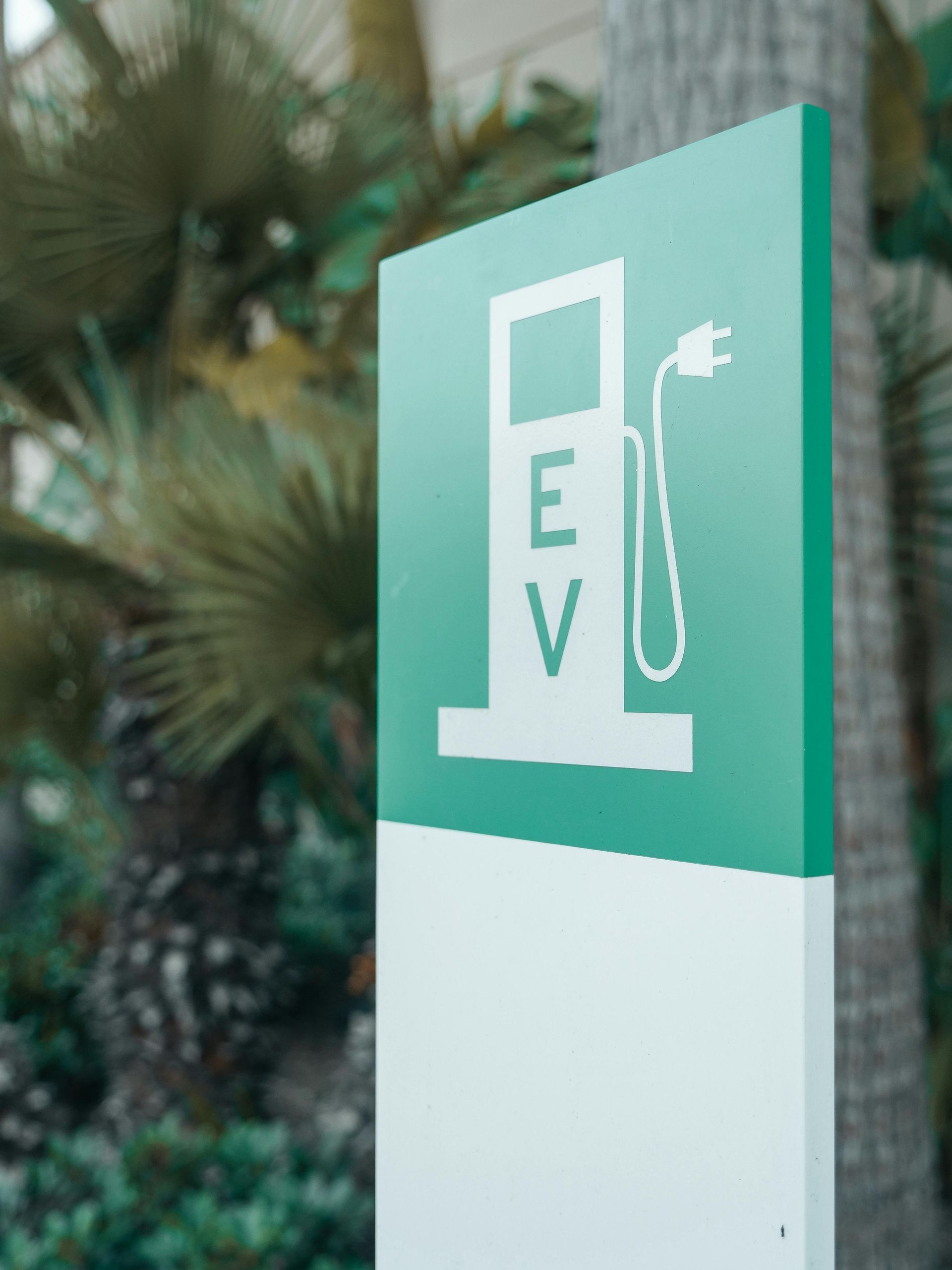 Electric vehicle charging station sign with green and white color scheme.