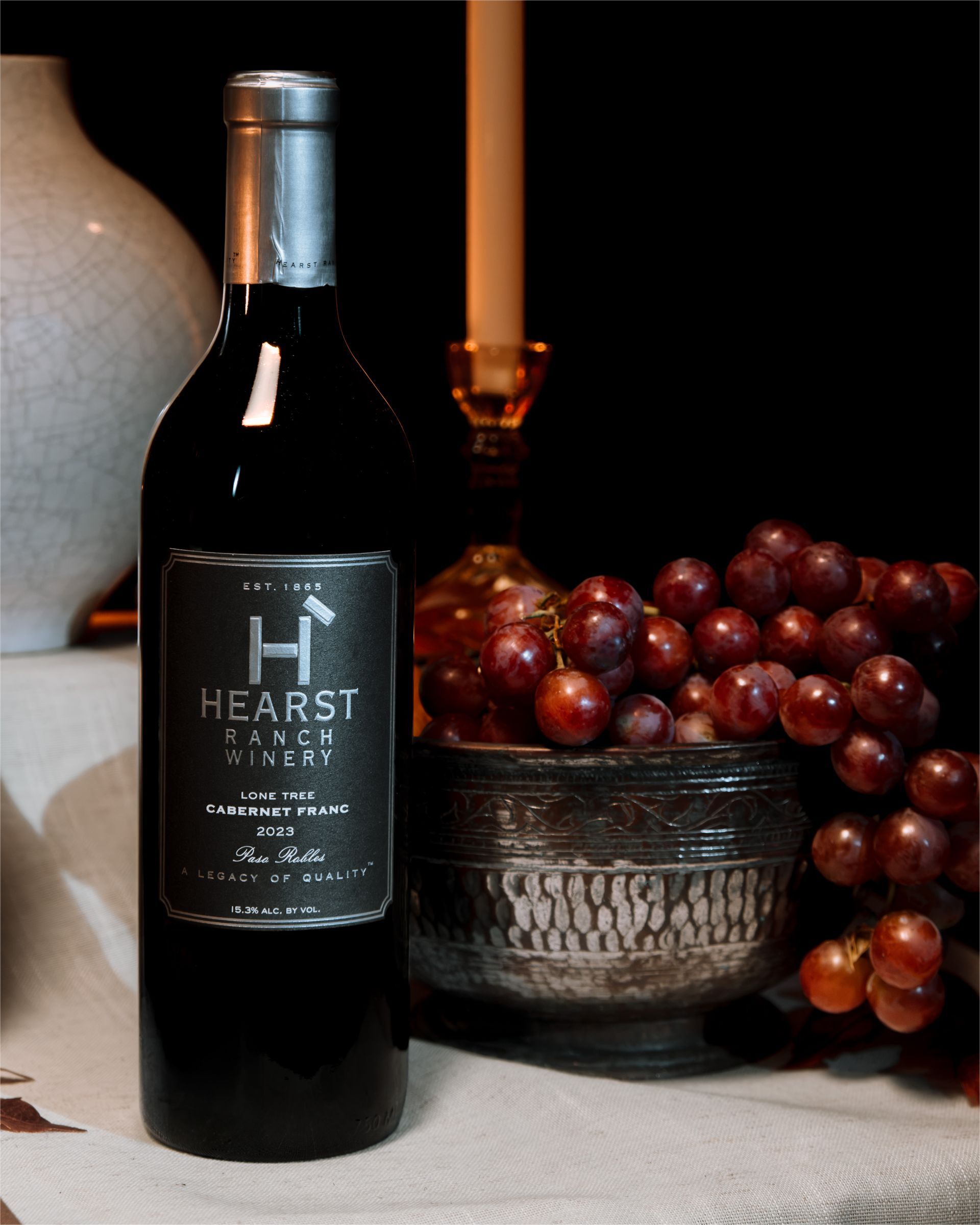 Two wine glasses being filled, one with white wine and one with red wine, against a warm background