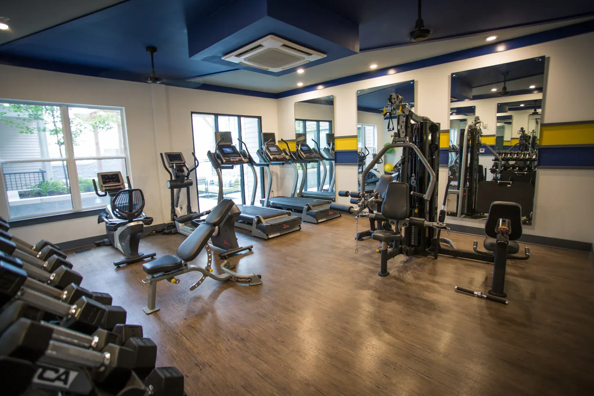 Indoor gym with treadmills, ellipticals, and weight machines in a modern facility.