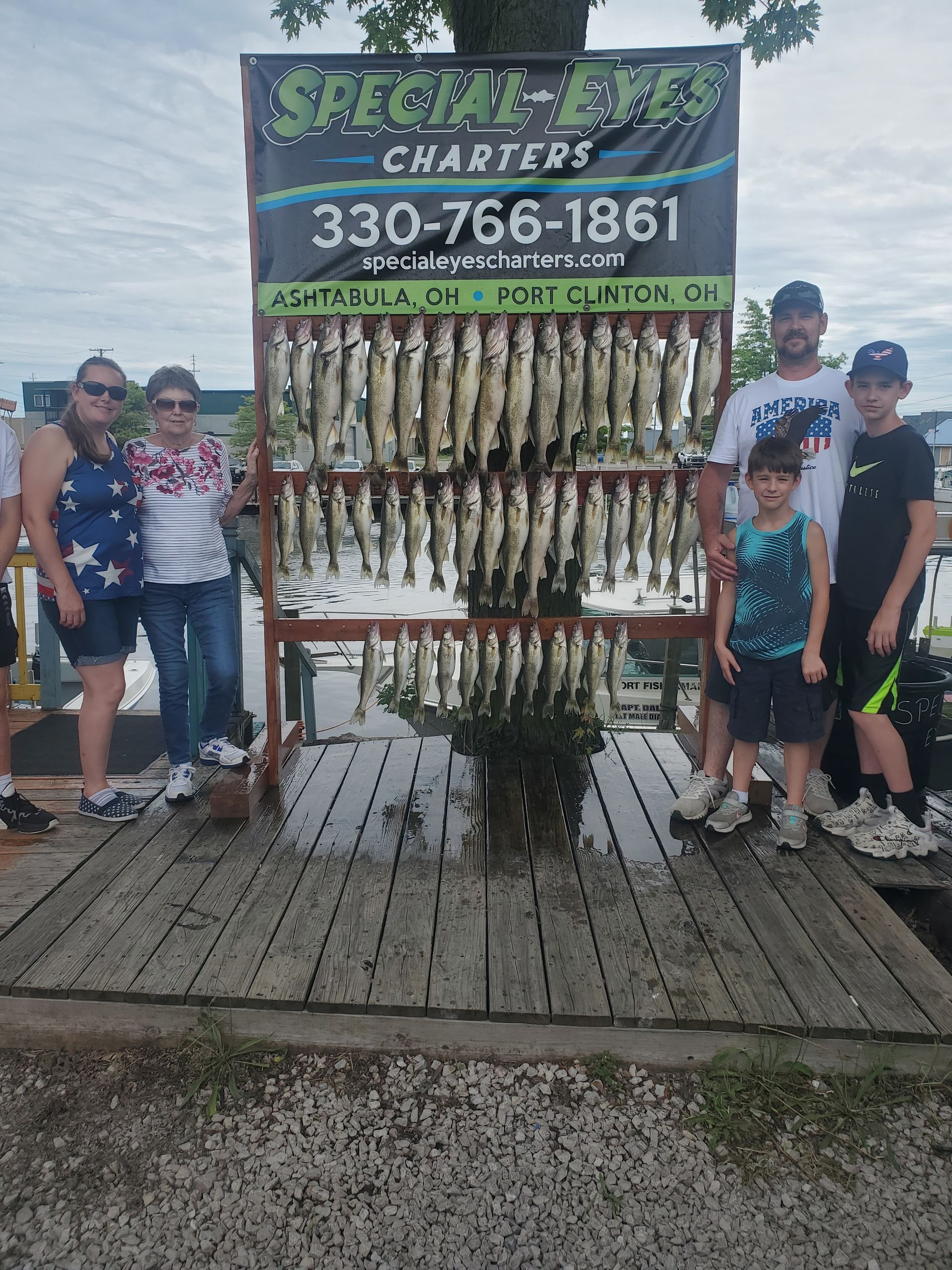 A family is posing for a picture in front of a display of fish.