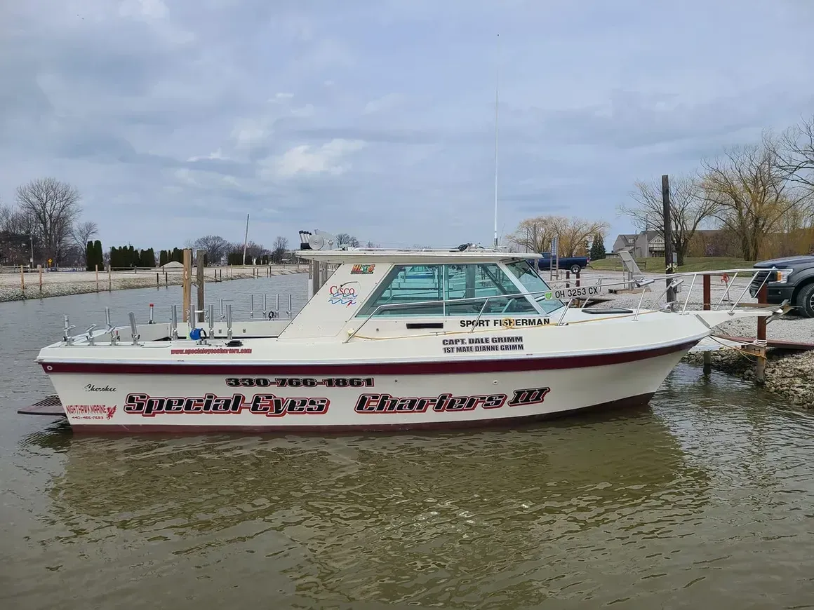 A boat is docked in the water and says special eyes on the side