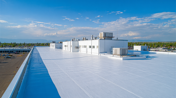 White commercial rooftop with HVAC units under a blue sky