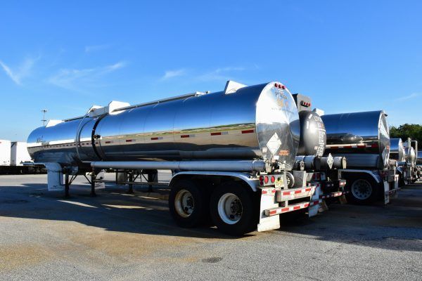 A row of tanker trucks are parked in a parking lot