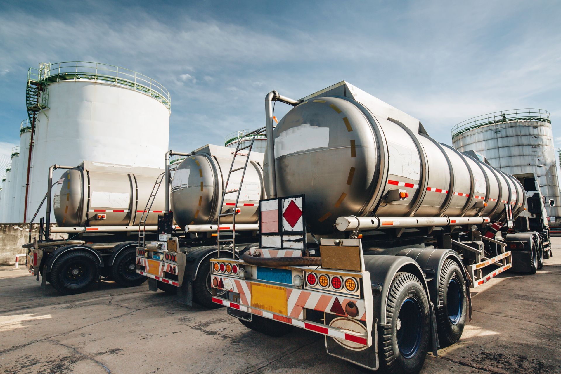 Two tanker trucks are parked next to each other in a parking lot.