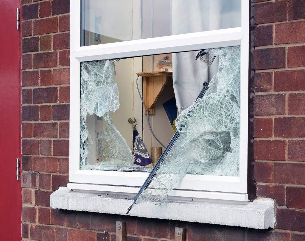 A brick building with a broken glass window