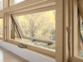 A close up of a wooden window with a view of a forest.