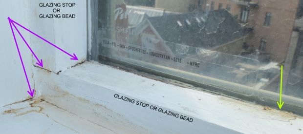 A picture of a window with arrows pointing to the glazing stop and glazing head.