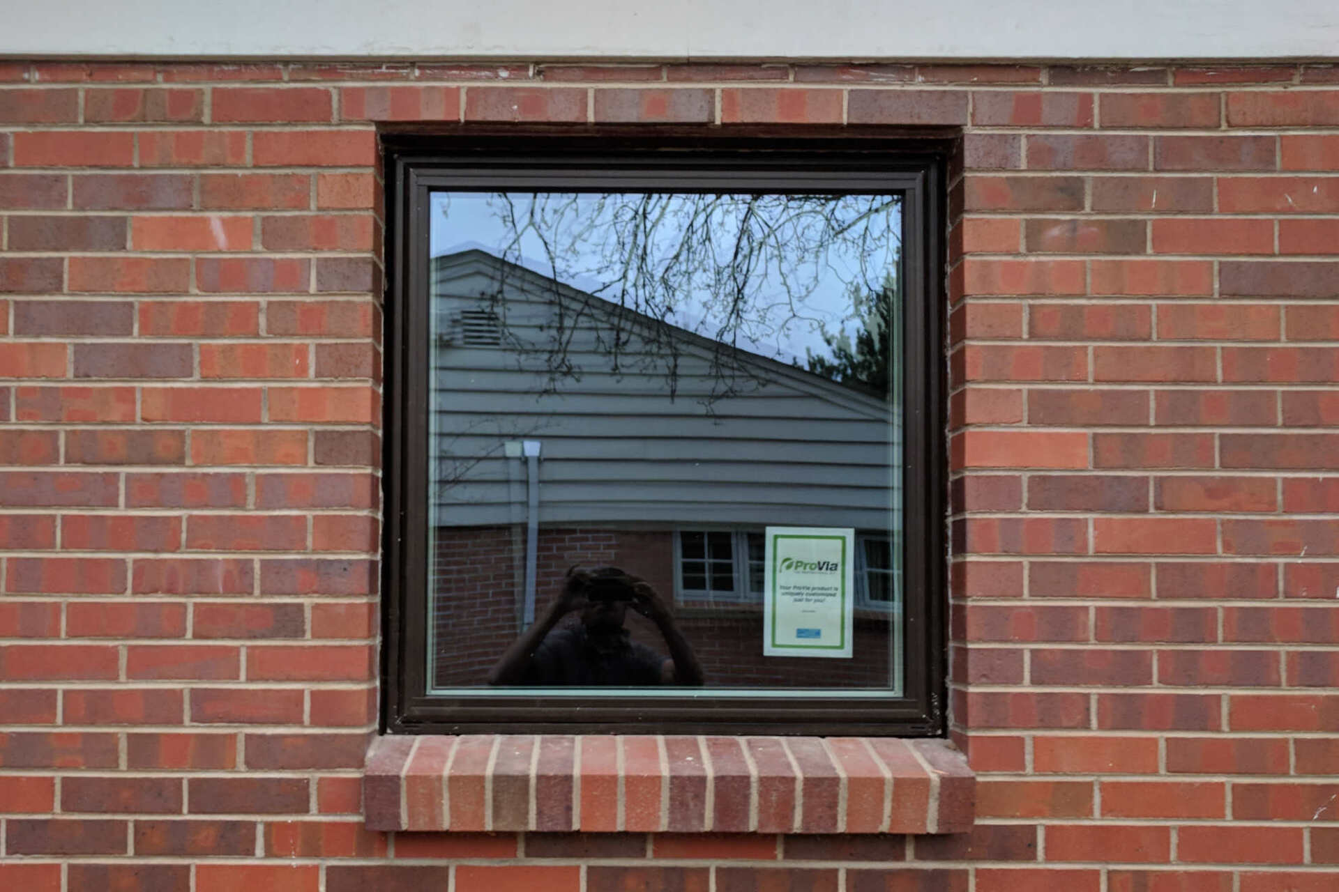 A brick wall with a window in the middle of it.