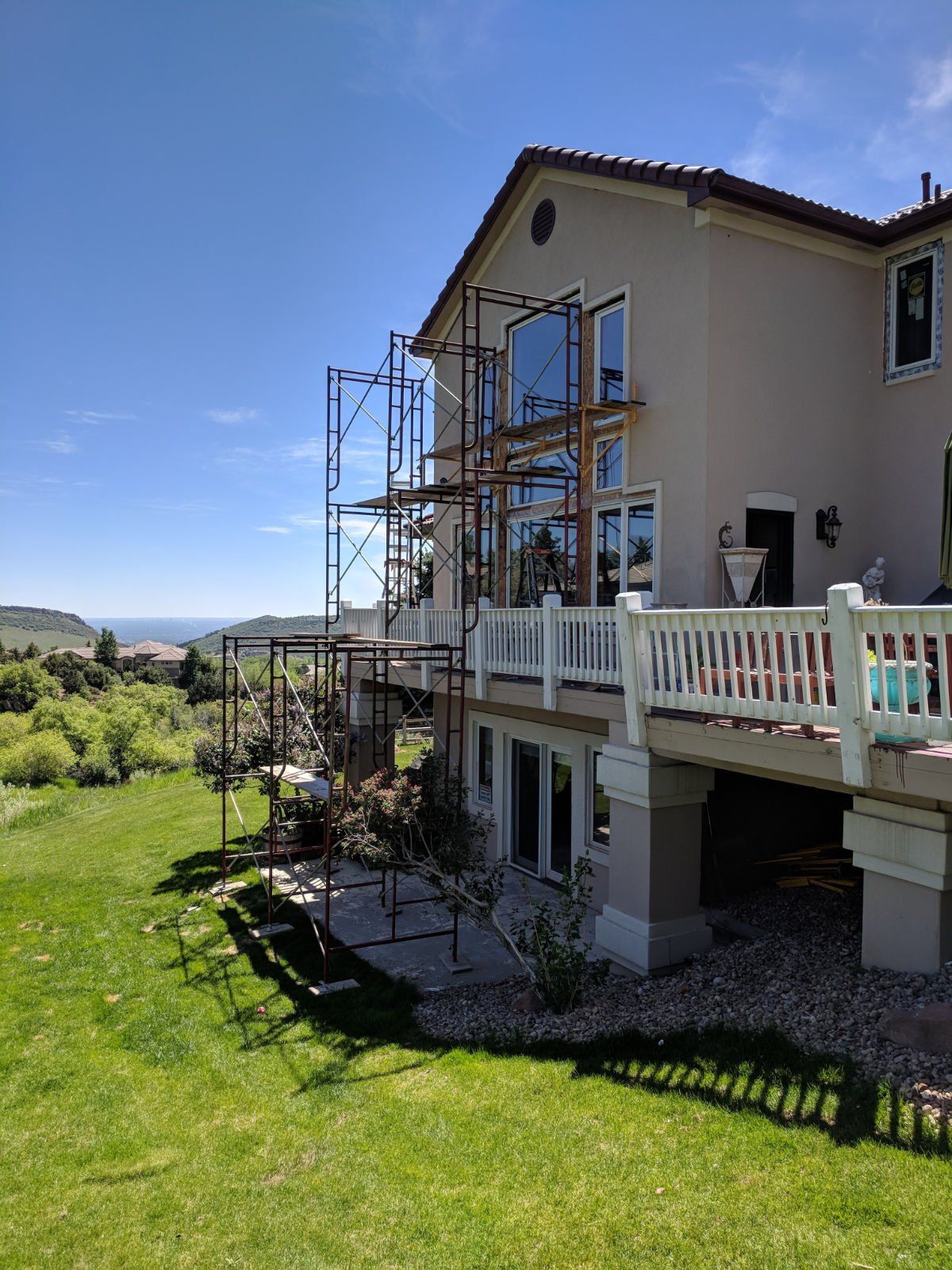 A large house with scaffolding around it is being painted.